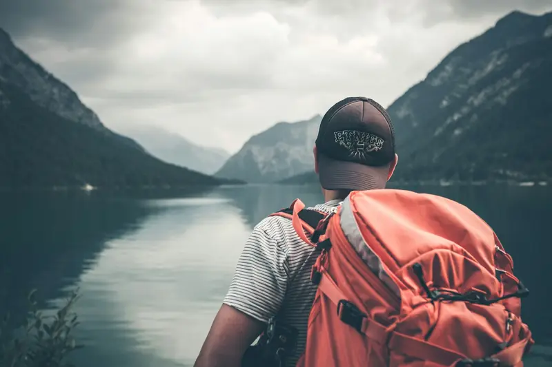 Traveller looking over a mountain lake and valley